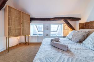 a bedroom with a large bed and a window at Le Duplex du Château – Fontainebleau Centre in Fontainebleau