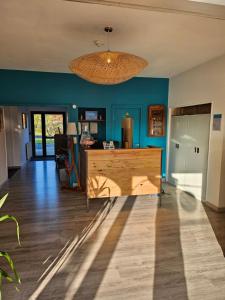a living room with blue walls and a chandelier at Domaine du Bocage in Chavagnes-en-Paillers
