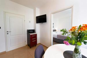 a room with a table with a vase of flowers at Apartments Lili in Pag