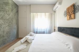 a bedroom with a large white bed with towels on it at Eudoxus Haus in Athens
