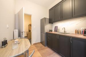 a kitchen with black cabinets and a table at Eudoxus Haus in Athens