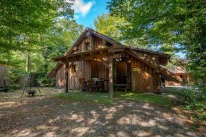 a cabin in the woods with a table and chairs at Camping Alsace Les Castors in Burnhaupt-le-Haut