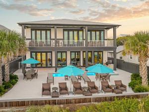 シーグローブ・ビーチにあるSeaside Serenityのパティオ(椅子、パラソル付)が備わる家