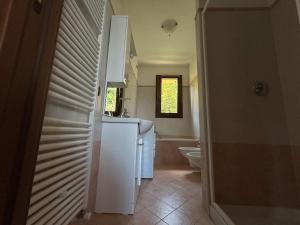 a white bathroom with a sink and a toilet at Lily apartment, Stunning Lake View in Germasino +55 photos