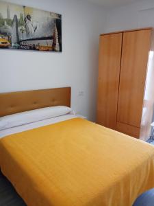 a bedroom with a yellow bed and a wooden cabinet at La Ferroviaria -Suite 1 Dormitorio Con Salón más Baño Privado - Balcón - 2º Sin Ascensor- in Zaragoza