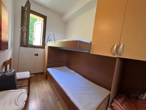 a small room with a bunk bed and a window at Lily apartment, Stunning Lake View in Germasino
