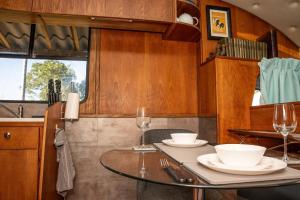 a dining room with a table and two wine glasses at Unique Glamping Experience - The Horse Box  +24 photos