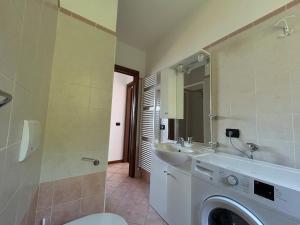 a bathroom with a washing machine and a sink at Lily apartment, Stunning Lake View in Germasino