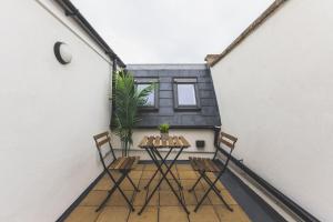 a balcony with a table and chairs on a building at Elegant 1BDR Flat with Private Patio in Twickenham