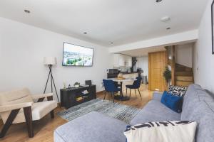 a living room with a couch and a tv at Elegant 1BDR Flat with Private Patio in Twickenham