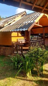 a patio with a table and chairs under a roof at Hometown Pai Boutique Bungalow in Pai