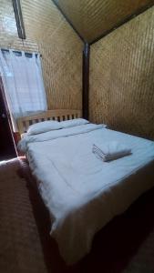a large bed with a white blanket and two forks at Hometown Pai Boutique Bungalow in Pai