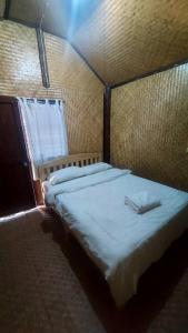 a large bed in a room with a window at Hometown Pai Boutique Bungalow in Pai +5 photos