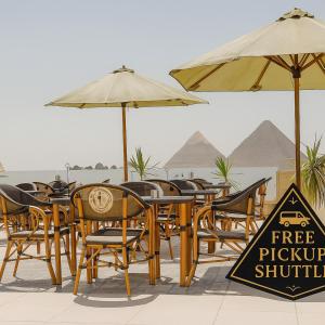 a group of tables and chairs with umbrellas at Five Pyramids Peaks View in Cairo