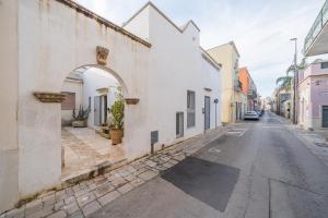 an alley with white buildings and an archway at Amazing Apartment Alla Corte with pool and sauna in Taurisano