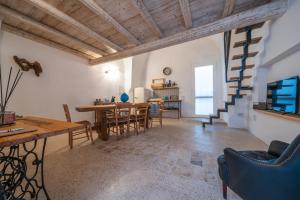 a living room with a table and chairs and a staircase at Amazing Apartment Alla Corte with pool and sauna in Taurisano