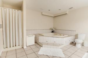 a bathroom with a tub and a toilet at Cozy Lakeview Retreat in Kettle Valley in Kelowna +4 photos