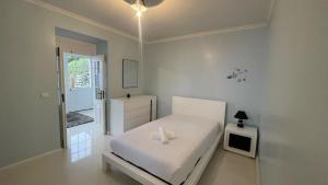 une chambre blanche avec un lit blanc et une télévision dans l'établissement Casa Borboleta, à Arco da Calheta
