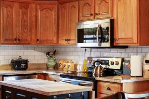 eine Küche mit Holzschränken und einem Herd mit Backofen in der Unterkunft Canyon Lake Haven Cabin Hot Tub Yard Bbq Fire Pit in Canyon Lake