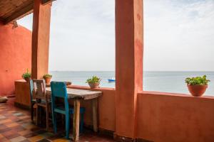 a table with chairs and a view of the ocean at Maison Crespin in Dakar