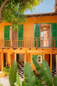 a house with green shutters and a porch at Maison Crespin in Dakar