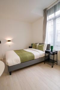 een slaapkamer met een bed en een raam bij Cinquantenaire 1 in Brussel