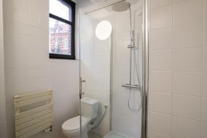 een witte badkamer met toilet en douche bij Cinquantenaire 1 in Brussel
