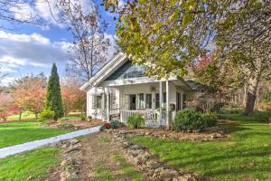 ein kleines weißes Haus mit einer Veranda in einem Hof in der Unterkunft Mtn Cottage with Fire Pit in Montezuma! in Montezuma