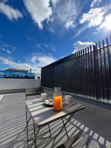 a table with a glass of orange juice on a balcony at A&R Atico Duplex Luxury I in San Sebastián de los Reyes