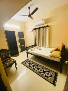 a bedroom with a bed and a chair and a rug at The Den -Villa -1 or 2BHK -Near - Airport -IT park in Chennai