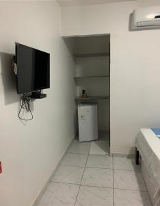 a room with a flat screen tv on a wall at Pousada Linhares in Canoa Quebrada