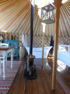 una estufa en una yurta con una mesa y una cama en Glamping Abruzzo - The Yurt, en Catignano