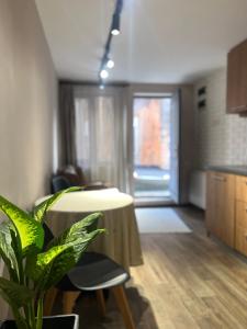 a dining room with a table and a plant in a room at Crown Hotel in Kutaisi