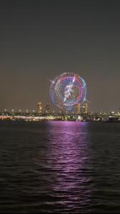 a ferris wheel is lit up at night at 둔촌트리하우스 Kspo in Seoul