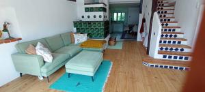 a living room with a green couch and a staircase at Auszeit-Oase im Waldviertel in Dobersberg +1 photo