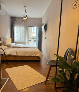 a bedroom with a bed and a chair and a window at Crown Hotel in Kutaisi