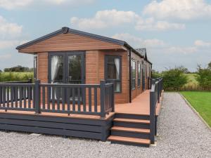 a wooden cabin with a deck and stairs at Meadows Park 4 in Hull