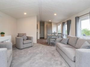 a living room with a couch and chairs and a table at Meadows Park 4 in Hull