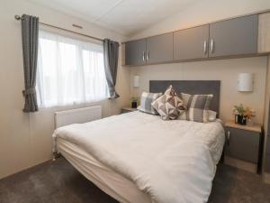 a bedroom with a large white bed and a window at Meadows Park 4 in Hull