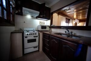 a kitchen with a stove and a microwave at casa dúplex a 50 metros del mar in Ostende +11 photos