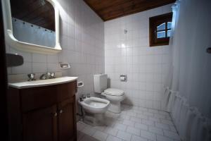 a white bathroom with a toilet and a sink at casa dúplex a 50 metros del mar in Ostende