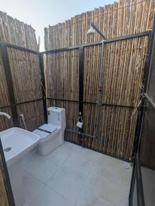 a bathroom with a toilet and a sink at Desert Lumen Camp in Al Raka