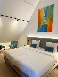 a bedroom with a large bed and a painting on the wall at Apartmenthaus Blauer Wolf by ROom for LIving Gunzenhausen in Gunzenhausen