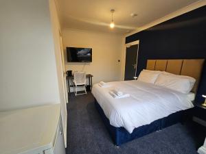 a bedroom with a large white bed with a desk at Airport Lodge in Sheldon