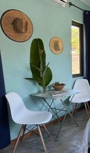 a table with two chairs and a plant on a wall at 5 Spots Studio in La Gaulette