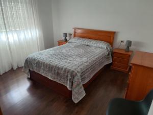 a bedroom with a bed and a desk and a chair at Nuestro hogar in Bueu +5 photos