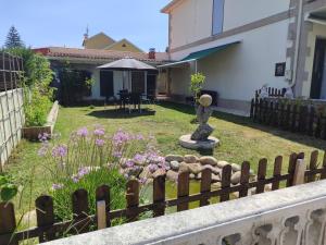 a garden with a fence and a fountain at Nuestro hogar in Bueu