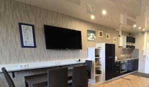 een woonkamer met een flatscreen-tv aan de muur bij Leuchtturm in Schönberg +11 foto's