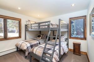 two bunk beds in a room with windows at Riverside A101 - Riverside Hummingbird in Telluride