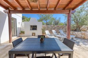 a patio with a table and chairs and a fireplace at Villa Elena in Marina di Pescoluse